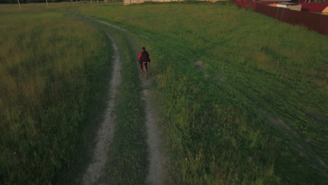 Steadicam-Luftaufnahme-Eines-Jungen,-Der-Im-Sommer-In-Russland-Fahrrad-Fährt