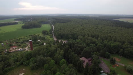 Aerial-flight-above-the-Lukino-Moscow-picturesque-landscape-of-green-forest-and-fields-countryside-buildings-and-traffic