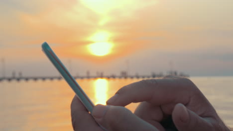 Bei-Sonnenuntergang-Auf-Dem-Smartphone-Tippen