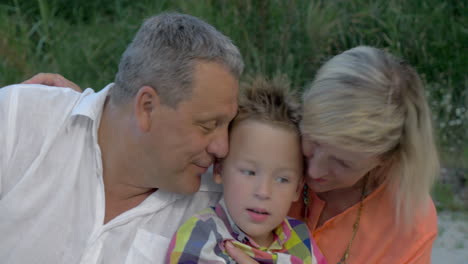 Grandparents-Hugging-and-Kissing-Their-Grandson