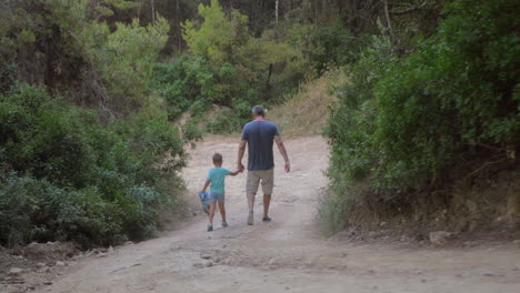 Father-and-son-walking-away-in-forest
