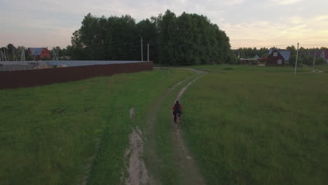 Vista-Aérea-Steadicam-De-Un-Niño-Andando-En-Bicicleta-En-El-Verano-Rusia