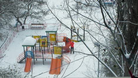 Mom-and-kid-having-fun-on-playground-in-winter