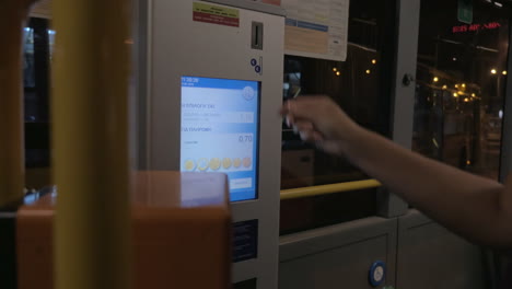 Woman-using-ticket-machine-to-pay-for-bus-ride