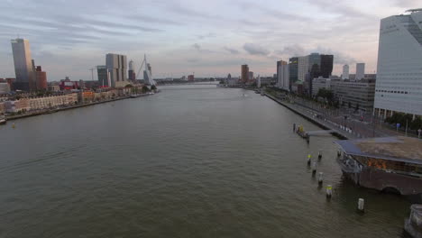 Luftaufnahme-Des-Stadtbildes-Mit-Modernen-Gebäuden-Am-Fluss-Vor-Bewölktem-Himmel-Rotterdam,-Niederlande