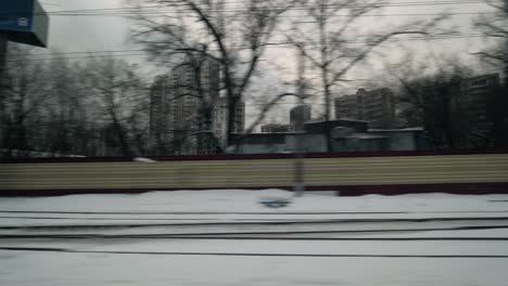 Passing-by-winter-city-view-from-moving-train