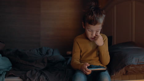 Kid-in-bedroom-browsing-web-on-smart-phone