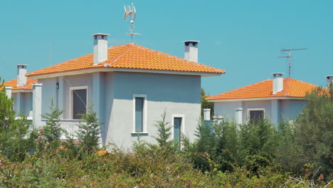 Graue-Häuser-Mit-Roten-Dächern