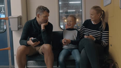 Blick-Auf-Eine-Glückliche-Familie-Auf-Der-Bahnfahrt-Mit-Dem-Smartphone-In-Amsterdam,-Niederlande