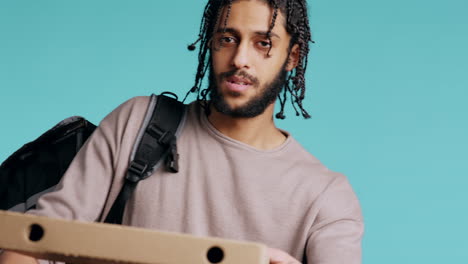 Portrait-of-BIPOC-courier-delivering-pizza-order-to-client,-camera-background