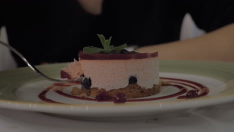 Woman-eating-mousse-dessert-with-berries-in-restaurant