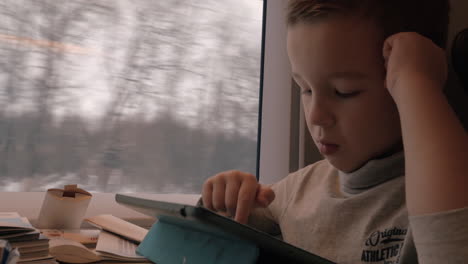 Kid-passing-the-time-with-pad-during-train-journey