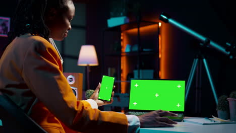 African-american-girl-uses-smartphone-and-pc-with-greenscreen