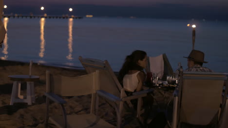 View-of-young-happy-couple-having-romantic-dinner-on-the-beach-Greece