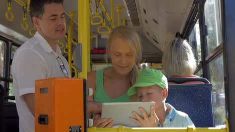 Young-family-with-child-using-pad-in-bus