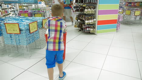 Kind-Mit-Einkaufswagen-Im-Laden