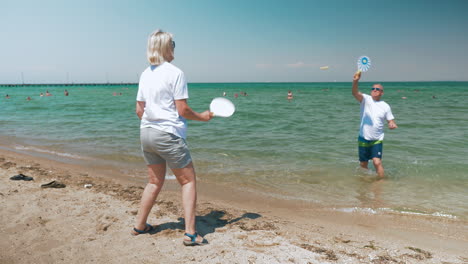 Älteres-Paar-Spielt-Schlägerball-Am-Strand
