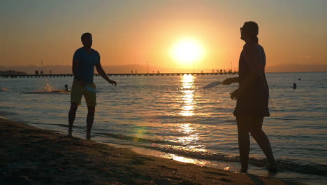 Couple-playing-tennis-on-the-beach-at-sunset