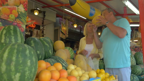 Man-and-woman-choosing-melon-in-market