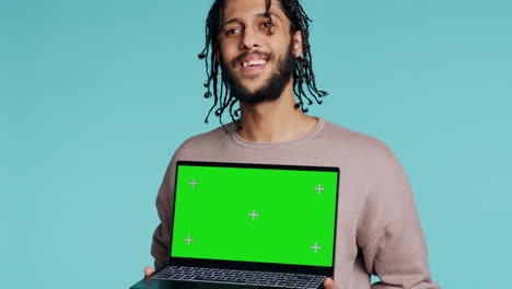 Smiling-person-presenting-chroma-key-notebook,-studio-background