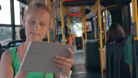 Smiling-Woman-with-Tablet-in-Bus