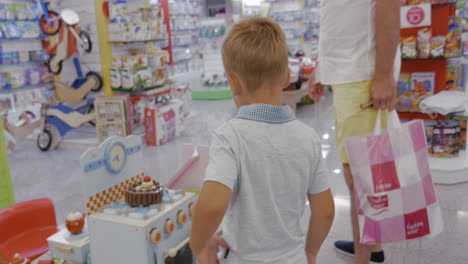 Child-is-attracted-with-toy-cooker-in-supermarket