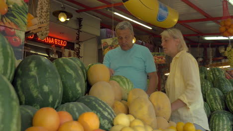 Family-couple-choosing-watermelon-on-street-market