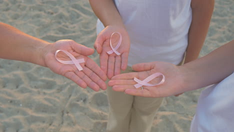 Three-Hands-Holding-Breast-Cancer-Awareness-Ribbon