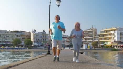 Senior-couple-jogging-with-music-on-the-pier