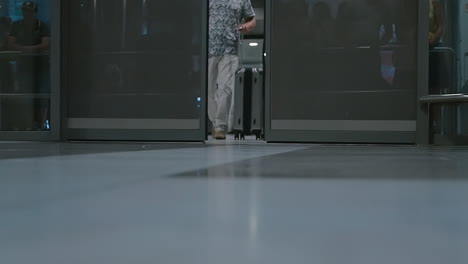 Männer-Mit-Koffern-Gehen-Am-Flughafen-Durch-Die-Türen