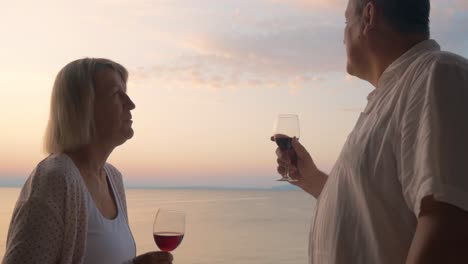 Mature-sweethearts-enjoying-sea-view-and-wine