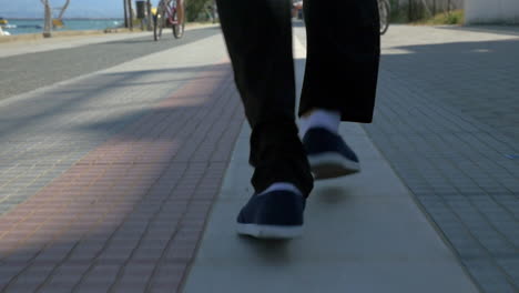 Male-feet-running-on-sidewalk-in-resort-town