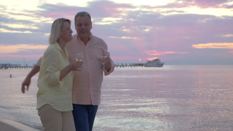Couple-having-romantic-seaside-walk-with-wine