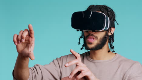 Man-wearing-virtual-reality-headset,-doing-swiping-gestures,-studio-background
