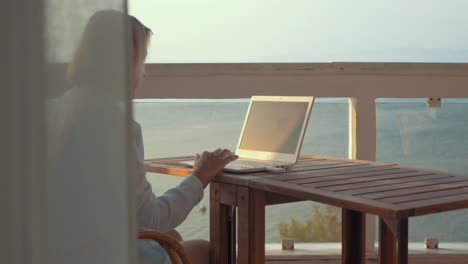 Woman-browsing-on-laptop-using-mobile-internet