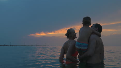 Parents-and-son-enjoying-evening-sky-while-bathing