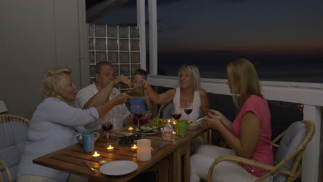 Family-having-meal-on-balcony-in-the-evening