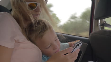 Mother-and-child-video-chatting-on-mobile-in-car