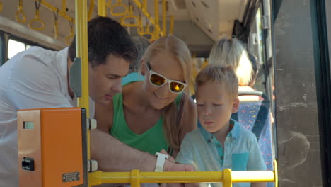 Child-using-fathers-smartwatch-during-bus-ride
