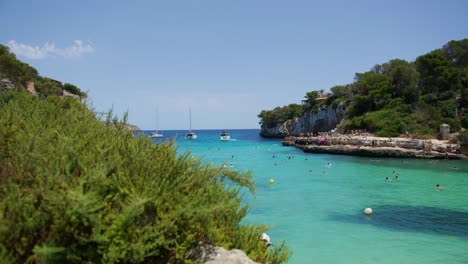 Mallorca:-Strandseitenansicht-Des-Resorts-In-Cala-Liombards-Auf-Der-Insel-Mallorca,-Spanien,-Europa-|-Hangblick-Auf-Strandbesucher