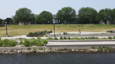 River-walk-in-front-of-the-Gerald-Ford-Presidential-Library-on-the-Grand-River,-aerial-view