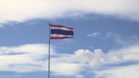 Ein-Blick-Aus-Der-Ferne-Auf-Die-Nationalflagge-Thailands,-Die-In-Der-Luft-Vor-Dem-Wolkenverhangenen-Blauen-Himmel-In-Thailand-Weht