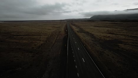 Filmische,-Leere-Straße-Aus-Der-Luft,-Felsige-Vulkanische-Bergnatur,-Epische,-Stimmungsvolle,-Dunkle-Landschaftslandschaft-Island