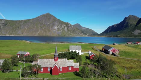 Red-wooden-church-in-Flakstad,-Lofoten-Islands,-Norway,-Scandinavia---Aerial-Circling