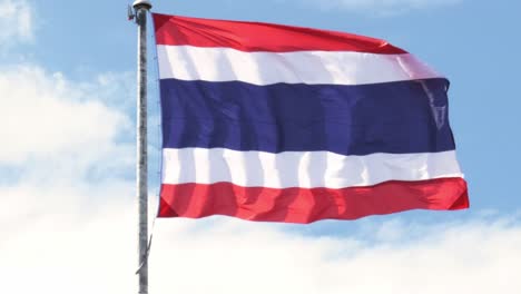 Nahaufnahme-Der-Thailändischen-Nationalflagge,-Die-Vor-Dem-Wolkenverhangenen-Blauen-Himmel-Weht