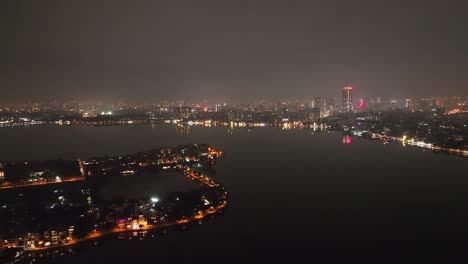 Dark-still-city-night-skyline-and-lake-with-atmospheric-haze-in-distance
