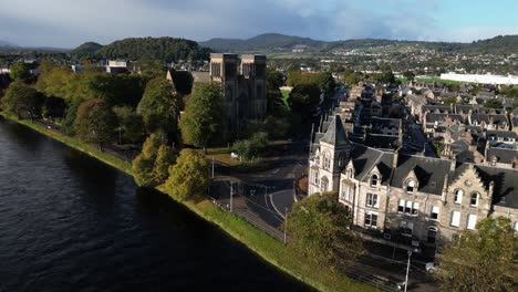 aerial-drone-footage-of-stone-town-homes-and-cathedral-on-Ness-river-in-Inverness,-Scotland-in-the-Highlands
