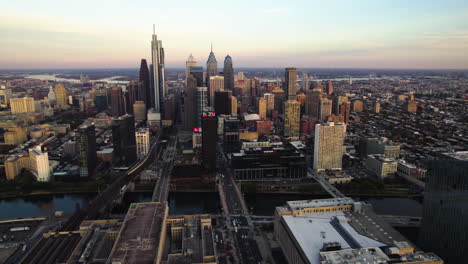 Establishing-drone-shot-rotating-toward-the-city-of-Philadelphia,-fall-evening
