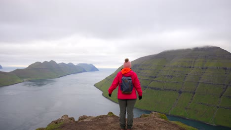 Eine-Nicht-Wiederzuerkennende-Wanderin-Streckt-Ihre-Arme-Aus,-Während-Sie-Vom-Berg-Klakkur-Aus-Die-Färöer-Inseln-Beobachtet