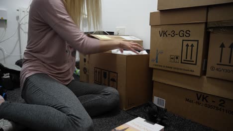 Woman-in-tracksuit-unpacking-things-in-new-apartment-after-moving-in